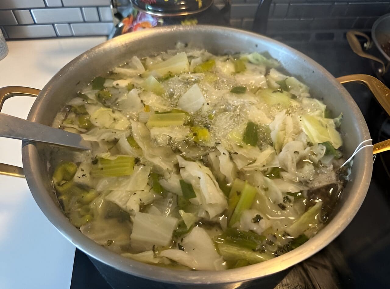 Here's an alt tag for the image: Simmering cabbage and celery soup.