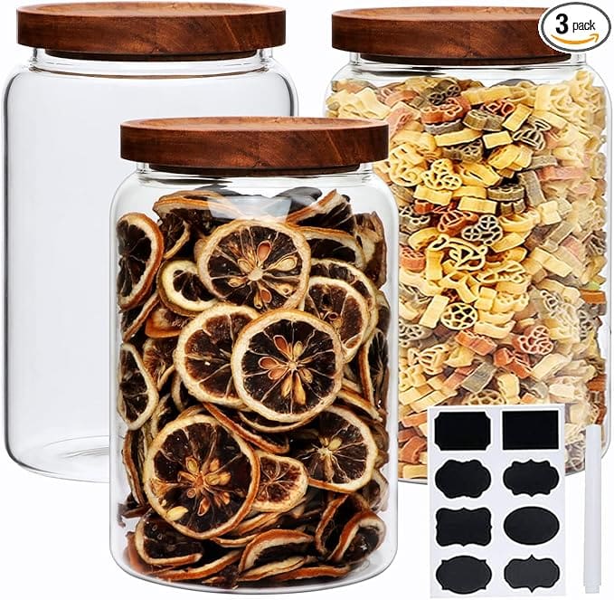 Three glass jars with wood lids, filled with food.