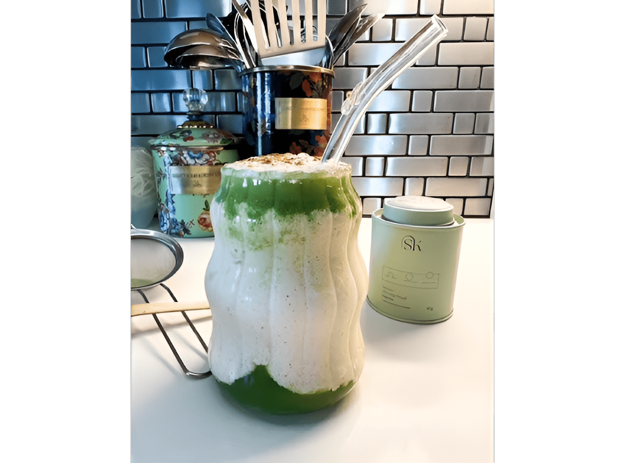 Layered matcha smoothie with straw.