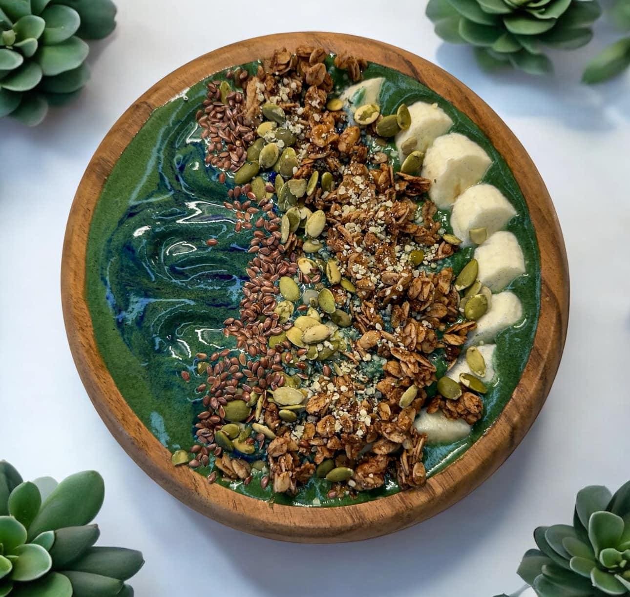 Green smoothie bowl with granola and seeds.