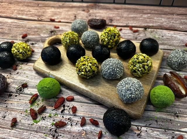 Assorted energy balls on wooden board.